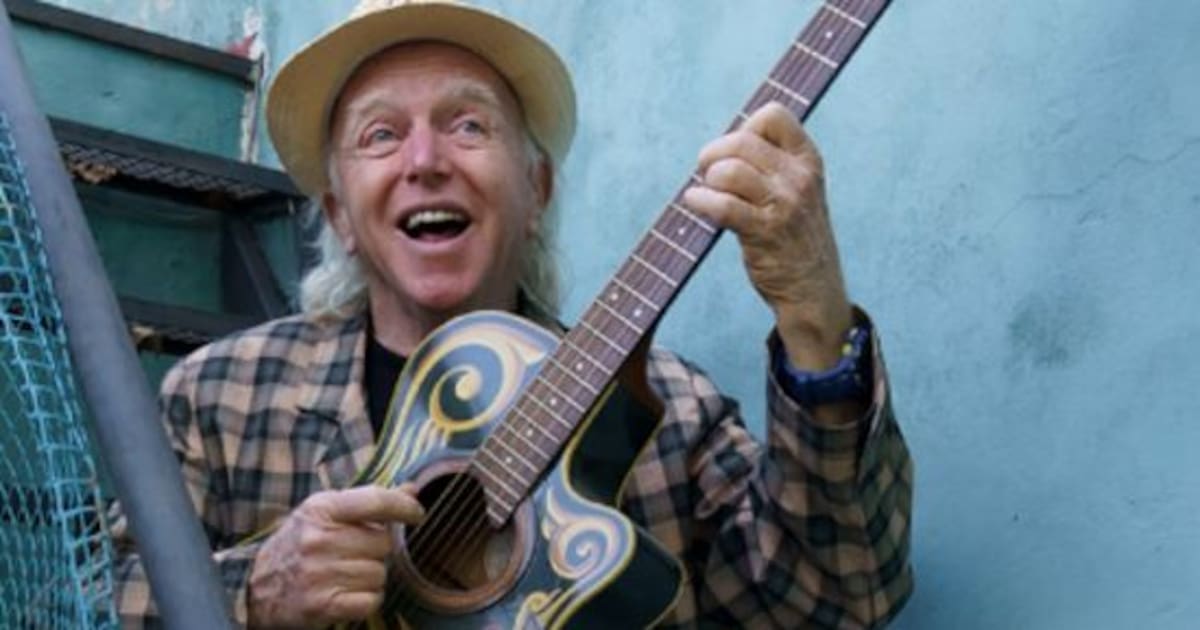 Miguel Cantilo con guitarra y sombrero